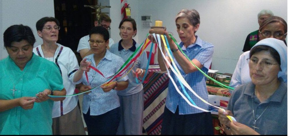 Hermanas y comunidad en una celebración con cintas de colores
